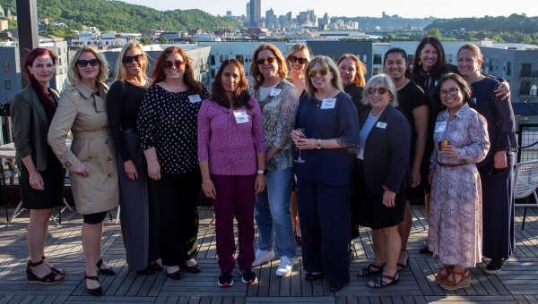 Women alumni gather in a group photo at an Executive Advantage networking event outdoors.