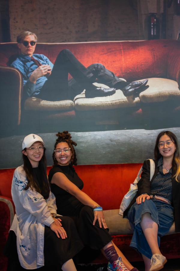 A photo of Arts Management Students beneath a picture of Andy Warhol at the Andy Warhol Museum in Pittsburgh