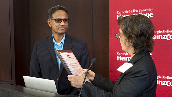 Krishnan is presented with a plaque during George D Smith Prize Ceremony